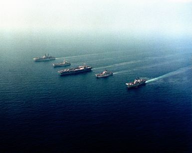 Ships from four nations sail alongside one another during the NATO Southern Region exercise DRAGON HAMMER '90. The ships are, from left: The British light aircraft carrier HMS INVINCIBLE (R-05), the Italian light aircraft carrier ITS GIUSEPPE GARIBALDI (C-551), the nuclear-powered aircraft carrier USS DWIGHT D. EISENHOWER (CVN 69, the Spanish aircraft carrier SPS PRINCIPE DE ASTURIAS (R-11) and the amphibious assault ship USS SAIPAN (LHA 2)