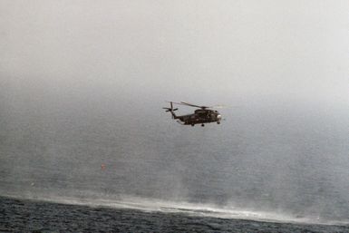 A right side view of a Helicopter Mine Countermeasures Squadron 14 (HM-14) RH-53D Sea Stallion helicopter towing a lightweight magnetic sweep during mine contermeasures operations. The helicopter is assigned to the amphibious assault ship USS GUAM (LPH 9). Note: Third view in a series of six