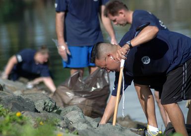 US Navy (USN) CHIEF Personnel SPECIALIST John Barroquillo (right) and Sailors assigned to Afloat Training Group (ATG), Middle Pacific (ATG MIDPAC), clean up trash and debris from the shorelines of historic Ford Island, Pearl Harbor, Hawaii (HI). Ford Island is adjacent to Battleship Row, home of the USN Iowa Class Battleship MISSOURI (BB 63) and USS ARIZONA Memorial