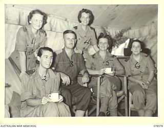 BOUGAINVILLE ISLAND. 1945-01-23. TX2142 LIEUTENANT COLONEL M.C. EDISON, COMMANDING OFFICER (3), DINING WITH SOME OF THE UNIT NURSING SISTERS DURING THE MORNING TEA BREAK AT THE 109TH CASUALTY ..