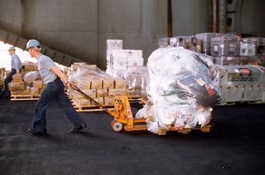 Members of the supply department on board the nuclear-powered aircraft carrier USS ABRAHAM LINCOLN (CVN-72) move hazmat material out onto one of the elevators in preparation for off loading the plastic storage trash as the ship docks at the Naval Base. The Navy does not dump trash at sea but returns it to shore for proper disposal