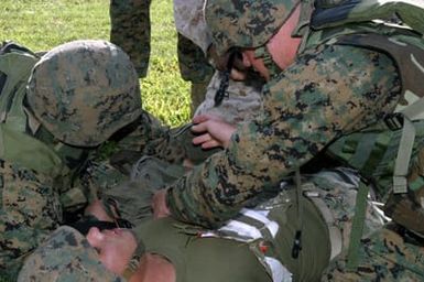 US Marine Corps (USMC) Marines, Golf Company, 2nd Battalion (BN) 3rd Marine Regiment, pretend to treat Lance Corporal (LCPL) Francos sucking chest wound as if were during an actual combat situation during Squad Competitions in preparation for the Super Squad Competition