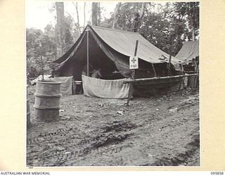 BORAM, WEWAK AREA, NEW GUINEA. 1945-08-31. PRIVATE C.V. WILLIAMS ATTENDING TO GUNNER D. MCDERMOTT AT THE REGIMENTAL AID POST, 2/3 FIELD REGIMENT, ROYAL AUSTRALIAN ARTILLERY