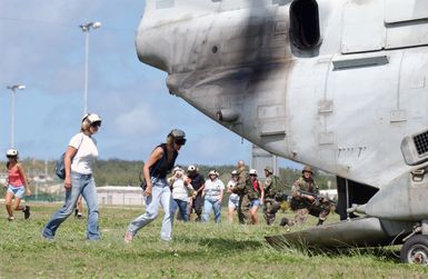 Civilian evacuees board a US Marine Corps (USMC) CH-46 Sea Knight helicopter, Marine Medium Helicopter Squadron 262 (HMM-262), Futenma, Japan, during a simulated non-combatant evacuation operation (NEO) at US Naval Forces Marianas Support Activity, Guam. The simulated NEO is part of Exercise TANDEM THRUST 2003, a joint military endeavor including forces from the United States, Canada and Australia
