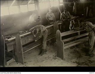 Port Moresby, New Guinea. 1944-05-13. Troops of 10 Anti-aircraft and Fortress Company, Royal Australian Engineers, building pews for St John's Church of England. Left to right: Sapper W. R. Pauley; ..