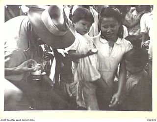 RABAUL AREA, NEW BRITAIN. 1945-09-13. CHINESE CIVILIANS, INTERNED BY THE JAPANESE AT A CAMP 15 MILES WEST OF RABAUL, WERE CONTACTED BY A PARTY OF AUSTRALIAN ARMY AND RED CROSS OFFICIALS SOON AFTER ..