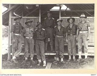 LAE, NEW GUINEA. 1944-12-21. OFFICERS OUTSIDE THE OFFICERS' MESS, 2/3 FORESTRY COY. IDENTIFIED PERSONNEL ARE:- CAPTAIN G BROWN, (1); LIEUTENANT E J BATES, (2); LT D H MUNRO, (3); CAPT J SEXTON, ..