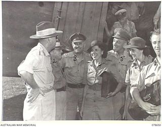 LAE AREA, NEW GUINEA. 1945-01-28. DICK BENTLEY, FAMOUS AUSTRALIAN ENTERTAINER AND MEMBERS OF HIS CONCERT PARTY CHATTING WITH NX135533 CAPTAIN E G M CUPIT, DEPUTY ASSISTANT DIRECTOR OF EDUCATION, ..