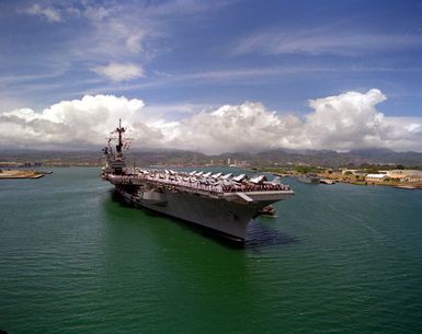 Sailors man the rails aboard the aircraft carrier USS RANGER (CV-61) as the vessel passes the U.S. Army Transportation Corps pier. The Army's vehicle landing ship CM3 HAROLD C. CLINGER (LSV-2) is moored to the pier. The RANGER is stopping off at Pearl Harbor while en route to its home port after returning from deployment in the Persian Gulf during Operation Desert Storm