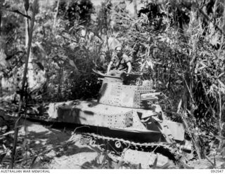 A PATROL FROM D COMPANY, 26 INFANTRY BATTALION (AUSTRALIAN IMPERIAL FORCE), EXAMINES A CAPTURED JAPANESE LATE MODEL TYPE 89 MEDIUM TANK, PROBABLY B MODEL WITH A DIESEL ENGINE, WHICH WAS DUG IN AND ..