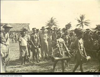 MADANG, NEW GUINEA. 1944-12-25. RAAF PERSONNEL ENJOYING THE UNUSUAL ENTERTAINMENT OF A NATIVE SING-SING ON CHRISTMAS DAY IN NEW GUINEA. ALL NEIGHBOURING TRIBES WERE REPRESENTED. THE UNUSUAL ..