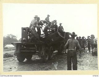 LAE, NEW GUINEA. 1944-08-09. MEMBERS OF THE 20TH FIELD COMPANY, UNLOADING A SECTION OF A NEW STEEL BRIDGE WHICH THEY ARE BUILDING ACROSS THE BUTIBUM RIVER TO REPLACE THE ONE WHICH WAS WASHED AWAY ..