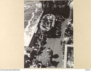 AT SEA, NEW GUINEA AREA. 1944-11-12. HEADQUARTERS 6 DIVISION TROOPS TRAVELLING TO AN OPERATIONAL AREA ABOARD USS MEXICO MAKE GOOD USE OF AVAILABLE SPACE PLAYING CARD GAMES, "HOUSIE", OR EVEN ..