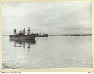 MILNE BAY, NEW GUINEA. 1944-07-05. AMERICAN "LIBERTY" SHIPS SHELTERING IN THE CALM WATERS BEHIND THE BOOM. THIS BOOM ENCLOSES AN AREA LARGE ENOUGH TO SHELTER SOME 200 VESSELS