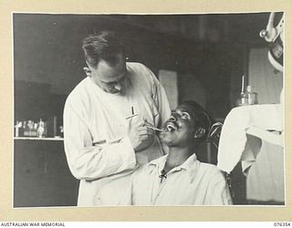 LAE, NEW GUINEA. 1944. NX77169 MAJOR G.S. COTTE, DENTAL OFFICER (1) FILLING TEETH FOR 17068 PRIVATE SAGA, 15TH FIELD COMPANY, INDIAN ARMY (2) AND EX PRISONER OF WAR OF THE JAPANESE WHO IS NOW A ..