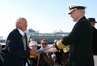 U.S. Navy Adm. Robert F. Willard (right) Vice CHIEF of Naval Operations (VCNO), presents Medal of Honor recipient U.S. Navy LT. ohn Finn with a newly created Medal of Honor Flag aboard the USS CONSTITUTION at Boston Harbor, Mass., on Sept. 30, 2006. As a U.S. Navy Aviation Ordnanceman, Finn was awarded the Medal of Honor for extraordinary heroism in manning a .50-caliber machine gun and fending off the attacks of apanese warplanes at Kaneohe Bay Naval Air Station, Hawaii, on the morning of Dec. 7, 1941. The Medal of Honor is our country's highest military honor, awarded for acts of valor above and beyond the call of duty. (U.S. Navy photo by Mass Communication SPECIALIST 1ST Class Chad...