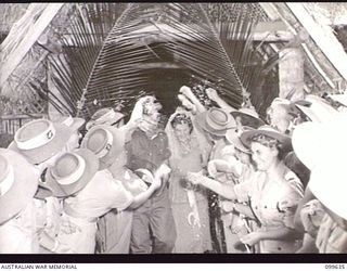 RABAUL, NEW BRITAIN, 1946-01-05. CORPORAL R. STANLEY, AUSTRALIAN MOVEMENT CONTROL, AND HIS BRIDE, FORMERLY PRIVATE BARBARA JAMES, AUSTRALIAN ARMY MEDICAL WOMEN'S SERVICE, LEAVING THE SACRED HEART ..