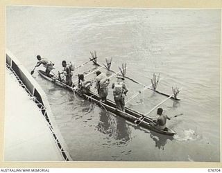 JACQUINOT BAY, NEW BRITAIN. 1944-11-06. MEMBERS OF B COMPANY, 1ST NEW GUINEA INFANTRY BATTALION GOING ASHORE IN A NATIVE LAKATOI FROM THE FRANCES PEAT, A FORMER HAWKESBURY RIVER, NEW SOUTH WALES, ..