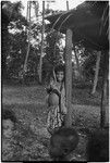 Smiling girl leans on a house post