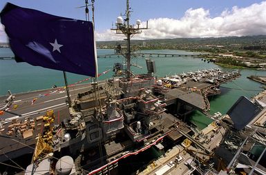 The soon to be decommissioned aircraft carrier USS INDEPENDENCE (CV 62), with bunting and flags, is shown as the flag of RDML Timothy J. Keating, Commander, Carrier Group Five, flies high above the aircraft carrier USS KITTY HAWK (CV-63) which is assuming her new duties as American's only permanently forward-deployed aircraft carrier