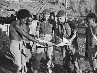 MOROKAIMORO, BOUGAINVILLE, 1945-06-07. NATIVE SCOUTS SUPPLIED BY ANGAU GREATLY ASSIST OUR TROOPS IN LOCATING TRACKS AND REPORTING MOVEMENTS OF THE ENEMY. HERE WITH LT H.J. ROBERTS, ANGAU (1) AND ..