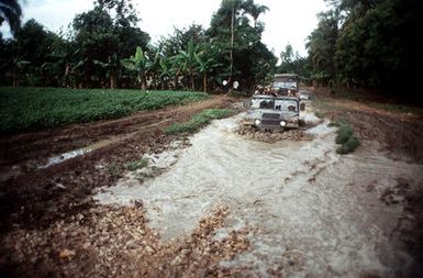 Soldiers in high mobility multi-purpose wheeled vehicles (HMMWV) of Alpha Company, 2nd Platoon, 4th Battalion, 22nd Infantry, 2nd Brigade, 25th Infantry Division (light), Schofield Barracks, Hawaii, negotiate the difficult and flooded road between Mirebalais and Loscahobas, Haiti on the afternoon of 21 February 1995. The soldiers will stay two days and two nights in Loscahobas, where they will conduct foot patrols and set up vehicle checkpoints during Operation Uphold Democracy