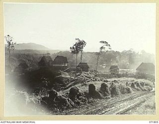 ILOLO, NEW GUINEA, 1944-03-30. THE ADMINISTRATIVE AREA OF THE AUSTRALIAN NEW GUINEA ADMINISTRATIVE UNIT NATIVE LABOUR CAMP VIEWING IMITA RIDGE IN THE LEFT BACKGROUND