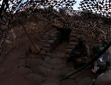 PFC Benjamin Holmes of Co. B, 1ST Bn., 35th Inf., 25th Inf. Div., on guard duty at the entrance of the newly constructed underground Tactical Operations Center during Operation Thunderbolt. Holmes is armed with an M-16A1 rifle/grenade launcher