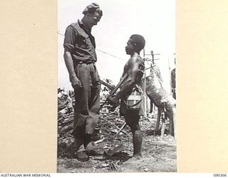 PURIATA RIVER AREA, BOUGAINVILLE. 1945-04-03. WARRANT OFFICER II MCCALLUM (1), TALKING TO PATA MANDE, SHORTEST MEMBER OF A COMPANY, NEW GUINEA INFANTRY BATTALION, ATTACHED 7 INFANTRY BRIGADE (2), ..