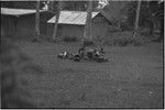 Mortuary ceremony: small group of women with bundles of grass skirts and other exchange items