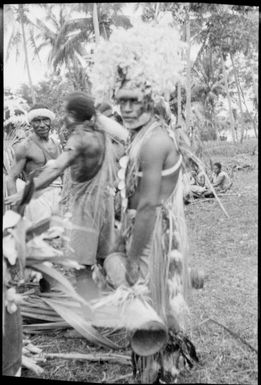 Several decorated dancers with one holding a hand drum, New Guinea, ca. 1929 / Sarah Chinnery