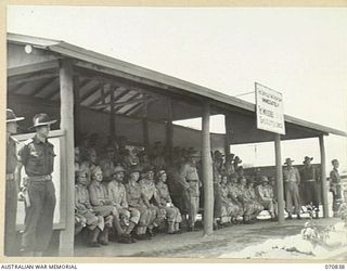 LAE, NEW GUINEA, 1944-03-08. OFFICIAL GUESTS FROM HEADQUARTERS, LAE BASE SUB AREA, THE 2/7TH AUSTRALIAN GENERAL HOSPITAL, UNITED STATES FORCES, AND THE ROYAL AUSTRALIAN AIR FORCE, WATCH VX20308 ..