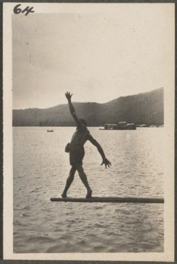 Papuan man trying to walk to end of pole before falling, Rabaul, New Britain Island, Papua New Guinea, approximately 1916, 2