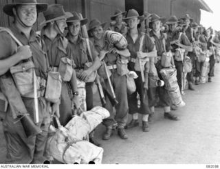 CAIRNS, QLD. 1944-10-30. TROOPS OF HEADQUARTERS COMPANY, 2/4 INFANTRY BATTALION, MOVING ALONG THE WHARF DURING EMBARKATION FOR NEW GUINEA ABOARD THE TROOPSHIP USS MEXICO. IDENTIFIED PERSONNEL ARE:- ..