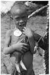 Child with pig with cord around leg