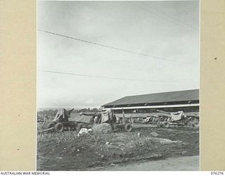 LAE, NEW GUINEA. 1944-09-27. ANTI-AIRCRAFT GUNS PARKED OUTSIDE THE ORDNANCE WORKSHOPS OF THE 43RD FIELD ORDNANCE DEPOT