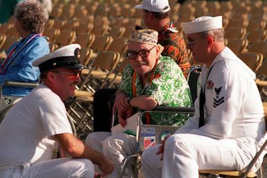 Raymond Sandlin, center, an Army Air Corps survivor of the Dec. 7, 1941, attack on Pearl Harbor, is interviewed by CHIEF Photographer's Mate Chet King of the Pacific Fleet Imaging Command while Sandlin's escort, PO1 F. Scott Wilson, right, looks on. Sandlin is listening to the music of the U.S. Pacific Fleet Band as they play period tunes during Remembrance Day ceremonies at the USS ARIZONA Memorial Visitors Center commemorating the 50th anniversary of the bombing
