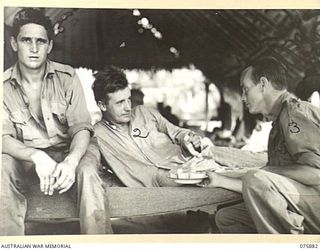 POTSDAM, NEW GUINEA. 1944-09-03. A MEDICAL ORDERLY OF THE 2/15TH FIELD AMBULANCE HANDING OUT SLICES OF PAW-PAW TO PATIENTS OF THE HOSPITAL. THIS FRUIT WAS OBTAINED BY MEMBERS OF THE 4TH SEA ..