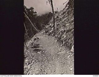 BULLDOG-WAU ROAD, NEW GUINEA, 1943-07-16. BENCHED PORTION OF THE ROAD AT THE 30 MILE POINT SHOWING EXCAVATION IN GRANITE BOULDER COUNTRY