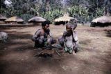 Papua New Guinea, Asaro mudmen resting by fire