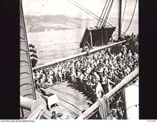 AT SEA, EN ROUTE TO MOROTAI, 15 APRIL 1945. MEMBERS OF 2/9 ARMOURED REGIMENT ATTENDING CHURCH PARADE ON NO 3 HATCH ABOARD THE UNITED STATES ARMY TRANSPORT, SS SEABARB. IN BACKGROUND CAN BE SEEN THE ..