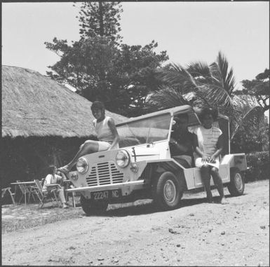 A man and two women in a Jeep, one sitting on the bonnet, Isle of Pines, New Caledonia, 1967 / Michael Terry