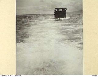 KELANOA AND BUTUBUTU, NEW GUINEA, 1944-02-08. A BARGE LOADED WITH TROOPS AND STORES OF HEADQUARTERS 5TH DIVISION SIGNALS, IN A ROUGH SEA BETWEEN KELANOA AND BUTUBUTU