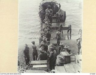 SARANG HARBOUR, NEW GUINEA. 1944-05-31. TROOPS AND STORES OF THE 37/52ND INFANTRY BATTALION UNLOADING FROM AN AMERICAN LANDING BARGE. THE AREA WAS USED AS A FORWARD BASE DURING PREPARATIONS FOR THE ..