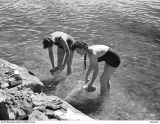 SALAMAUA, NEW GUINEA. 1945-05-19. AUSTRALIAN WOMEN'S ARMY SERVICE PERSONNEL WASHING THEIR MESS TINS AFTER A PICNIC LUNCH AT SALAMAUA. THE LAUNCH TRIP FROM LAE TO SALAMAUA WAS ORGANISED BY ARMY ..