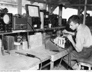 LAE, NEW GUINEA. 1944-06-09. TX3302 SERGEANT H. SMITH (1), TESTING RADIO EQUIPMENT AFTER ITS REPAIR IN THE WIRELESS SECTION OF THE 2/7TH ADVANCED WORKSHOP