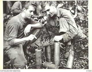 1943-08-16. NEW GUINEA. MOUNT TAMBU. 1ST CLASS PRIVATE EARL ANDERSON AND SERGEANT EUGENE ADER, BOTH OF PORTLAND, OREGON, PLAYING CHECKERS IN BETWEEN BOMBARDING JAPANESE POSITIONS ON MOUNT TAMBU AND ..