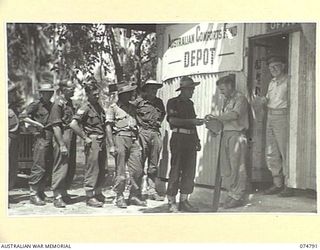 MADANG, NEW GUINEA. 1944-07-16. AUSTRALIAN TROOPS RECEIVING THEIR ISSUE OF THE COMFORTS FROM AN AUSTRALIAN COMFORTS FUND OFFICER, MAJOR HEARNE, OFFICER- IN- CHARGE IS STANDING IN THE DOORWAY