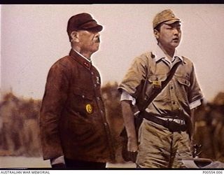 Commander of the 18th Japanese Army in New Guinea, Lieutenant General Hatazo Adachi, with his Japanese interpreter at the table at which he signed the surrender document marking the defeat of the ..