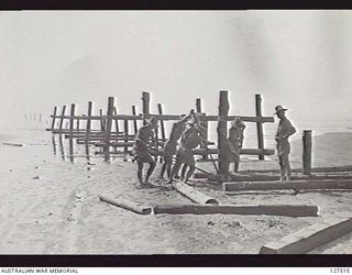 WANIGELA, NEW GUINEA. 1942-10. SAPPERS OF 2/4TH AUSTRALIAN FIELD COMPANY BUILDING A JETTY